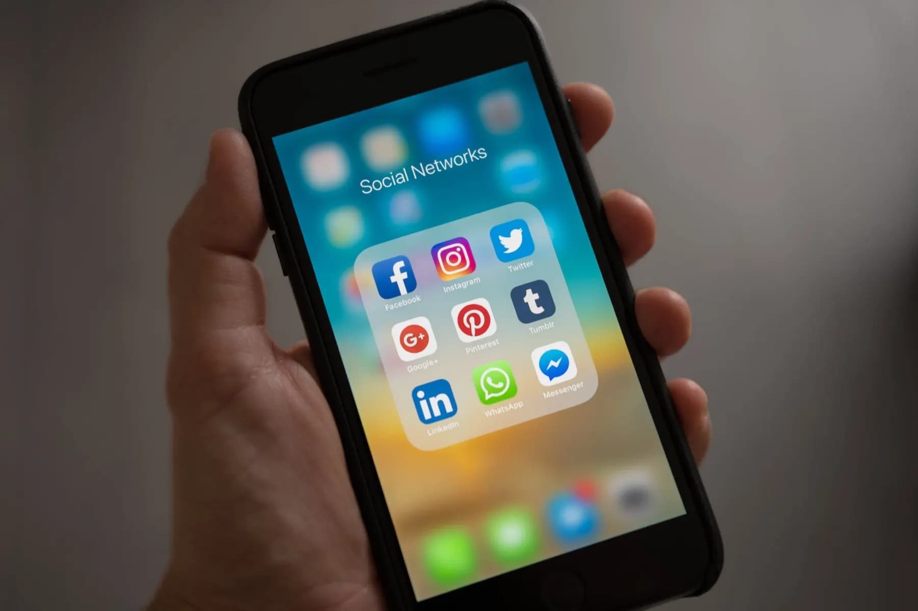 Mano sosteniendo un teléfono con aplicaciones de redes sociales